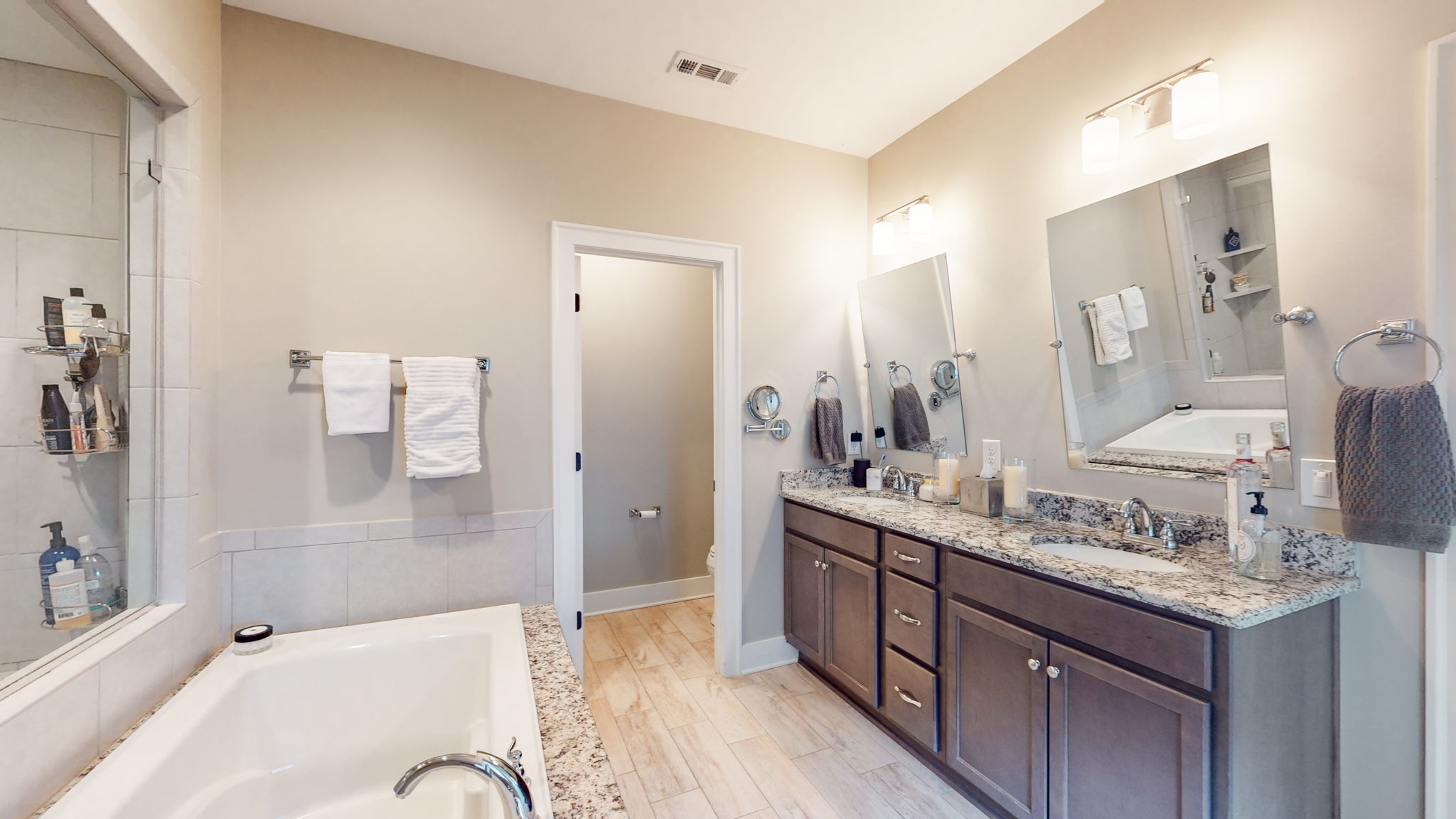 The spa-like Master Bathroom features a double vanity, extra large shower, separate soaking tub, custom walk-in closet, and water closet for privacy.