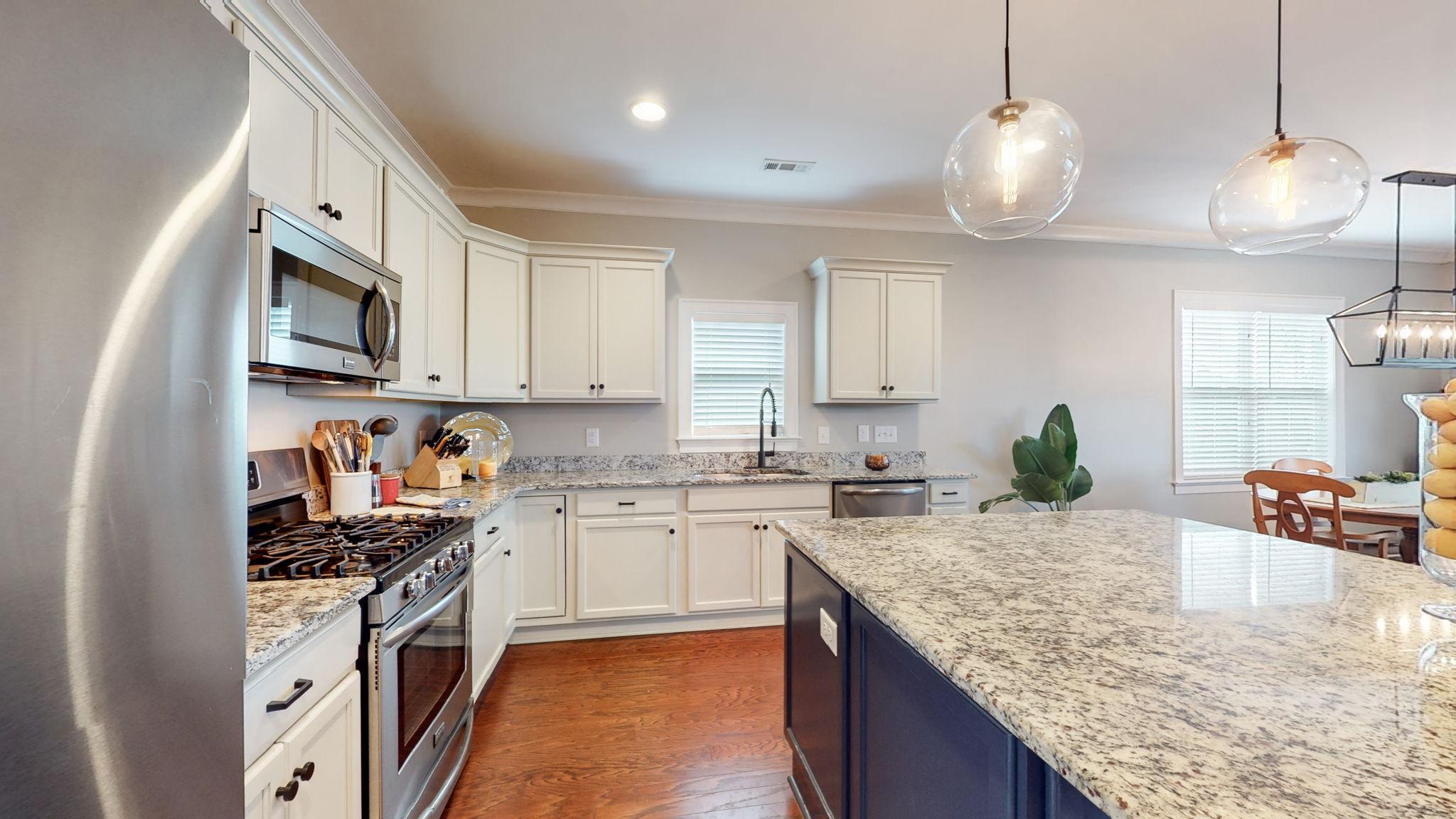 White cabinets, large island, and custom organizer in pantry.