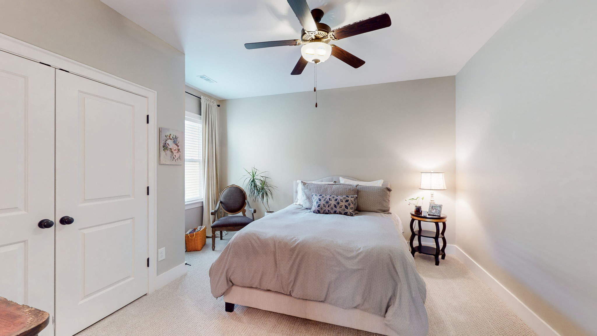The guest rooms are located at the front of the house. This one features a south facing window for natural light, a large closet, carpet, and a large ceiling fan.