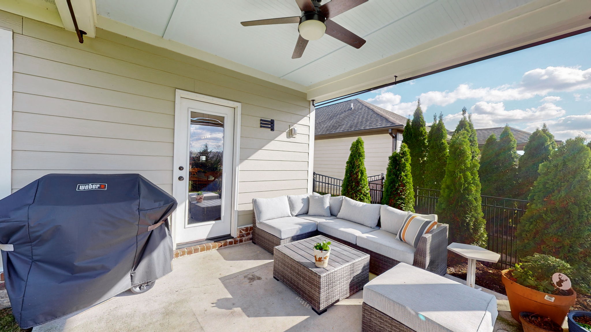 The outdoor patio features privacy trees to the south, ceiling fan, and cable hookups.
