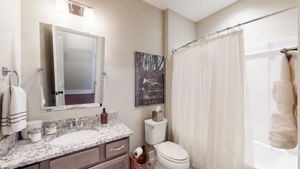 The guest bathroom towards the front of the home features granite counertops and combo shower & bathtub..