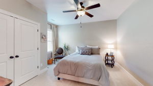 The guest rooms are located at the front of the house. This one features a south facing window for natural light, a large closet, carpet, and a large ceiling fan.
