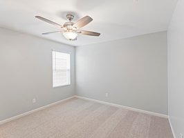 Secondary bedroom with walk-in closet and ceiling fan