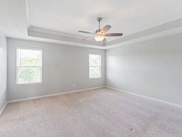 Primary Bedroom with trey ceiling & ceiling fan