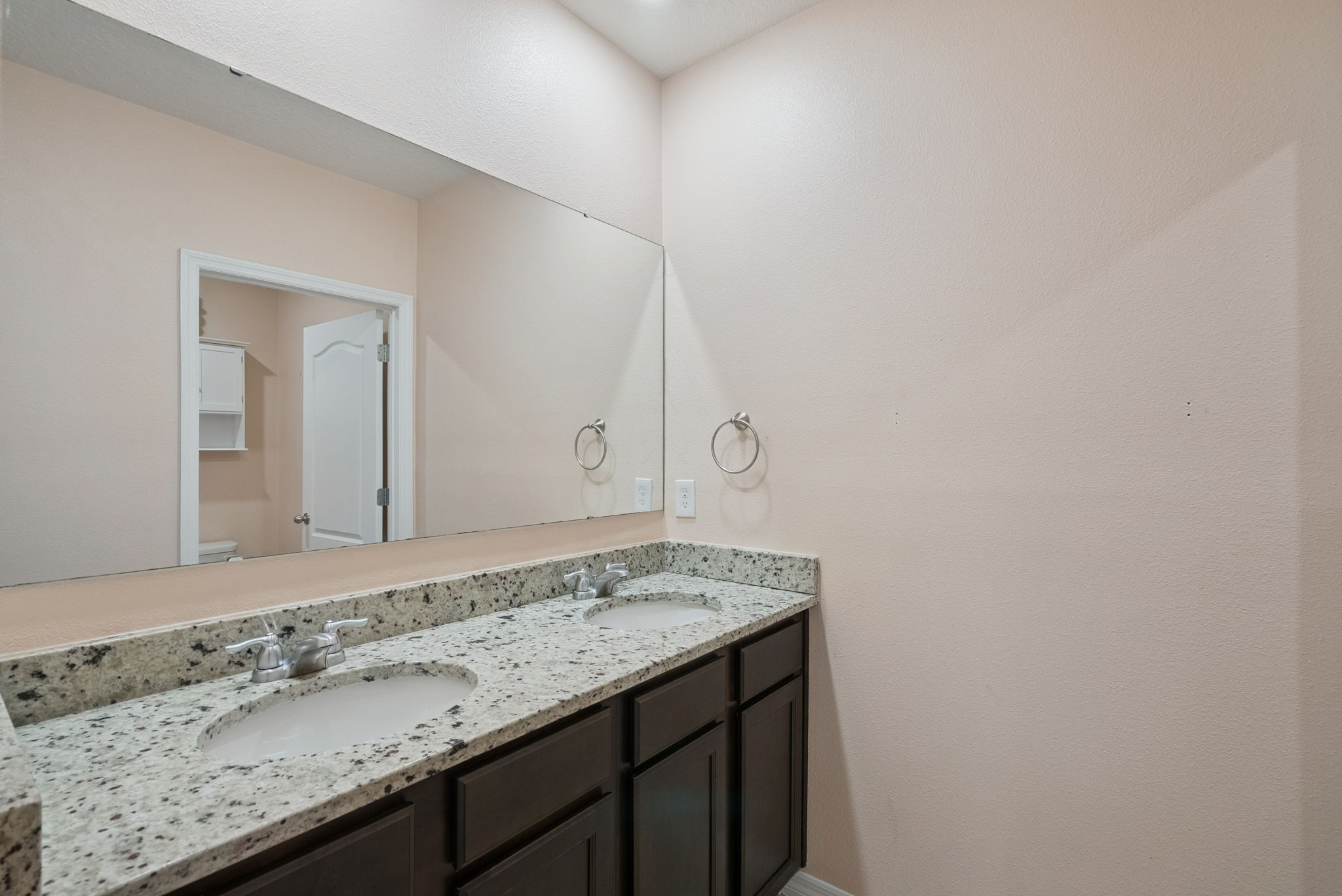 Upstairs full bathroom with dual sinks and shower