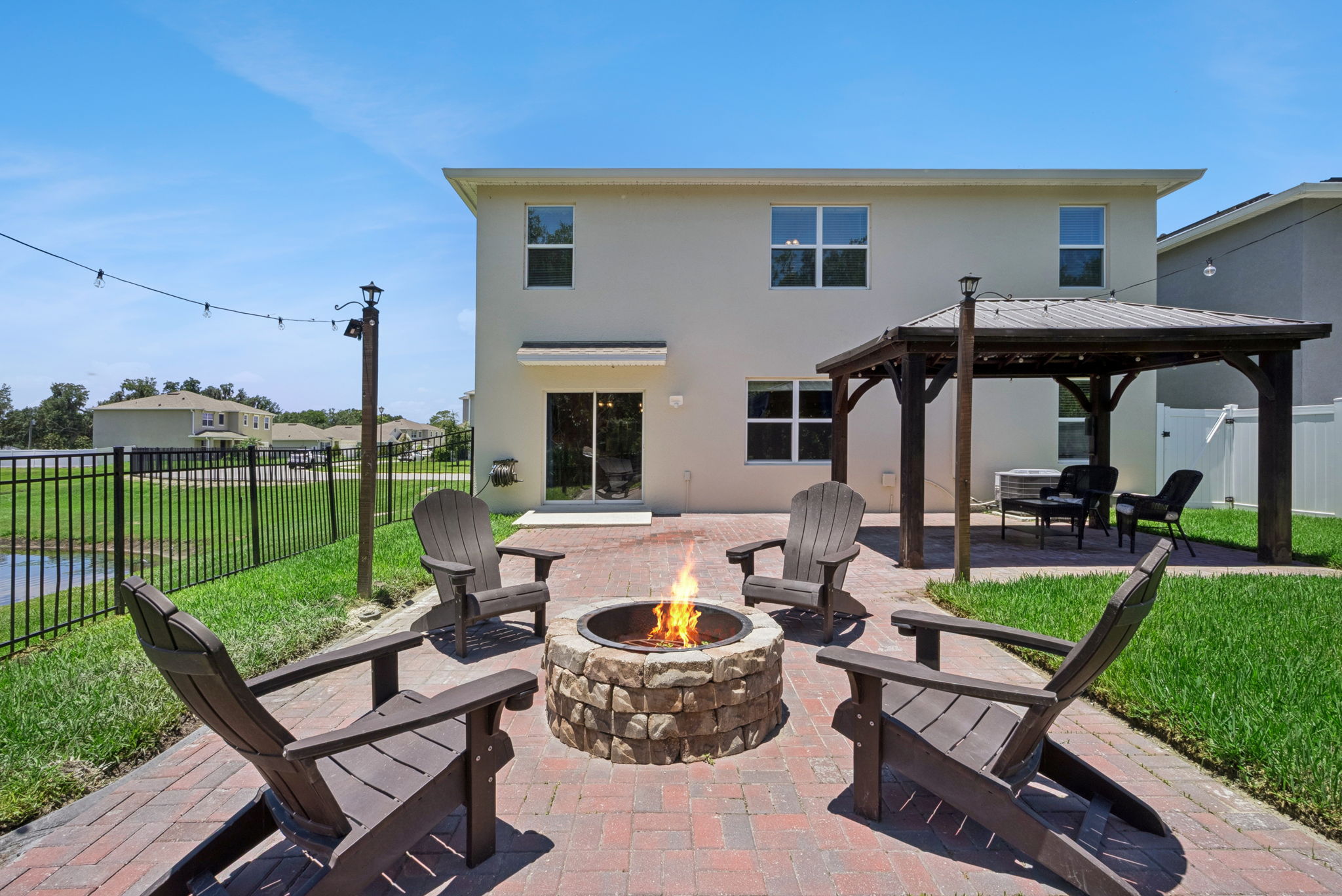 Fire pit, gazebo,large paved patio facing pond on one side and partially wooded on the other side