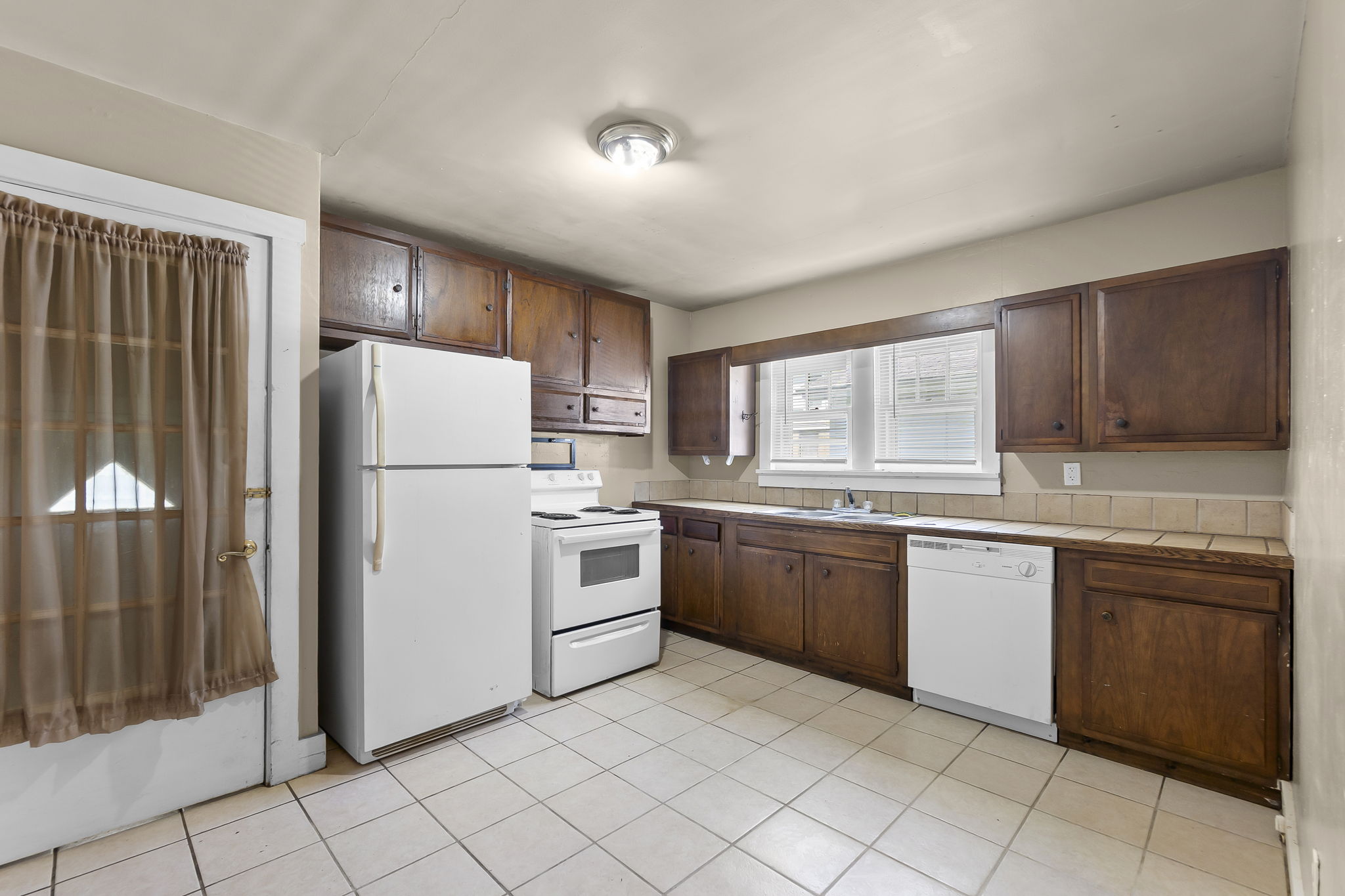 Kitchen dining combo with ceramic tile and view of entry to basement and backyard
