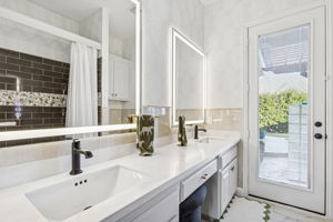 Secondary bathroom with double sinks, LED mirrors, quartz countertops