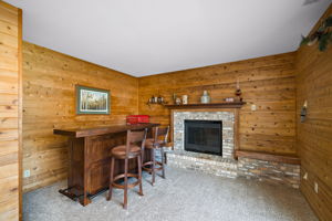 Hearth room with brick front gas fireplace and rustic wood paneling (3rd level)