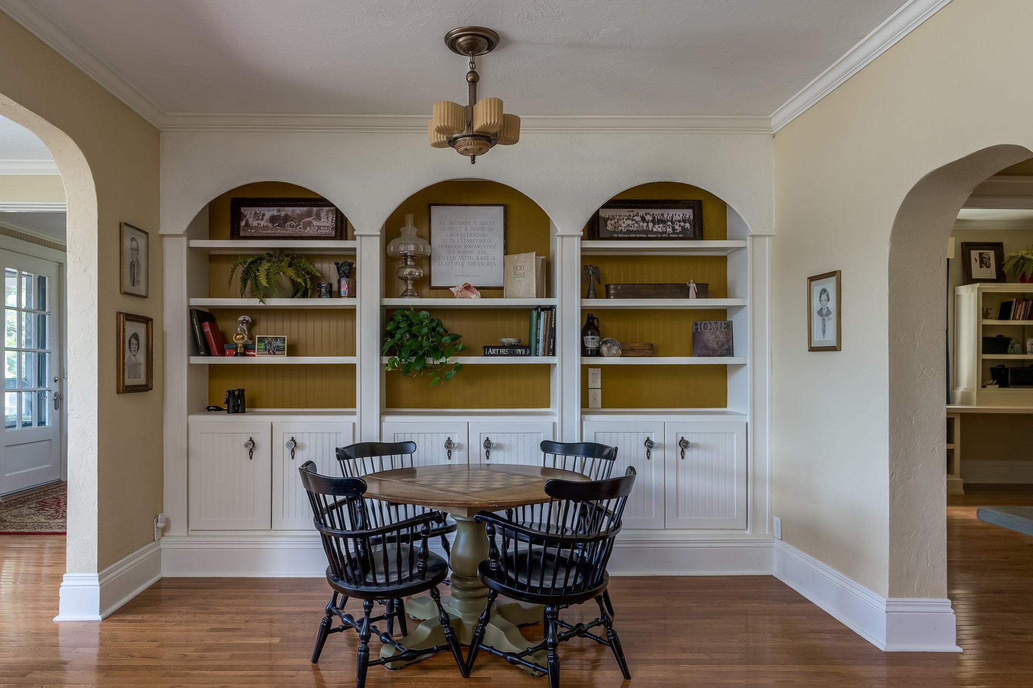 custom bookcases and a restored antique ceiling light over the gaming table