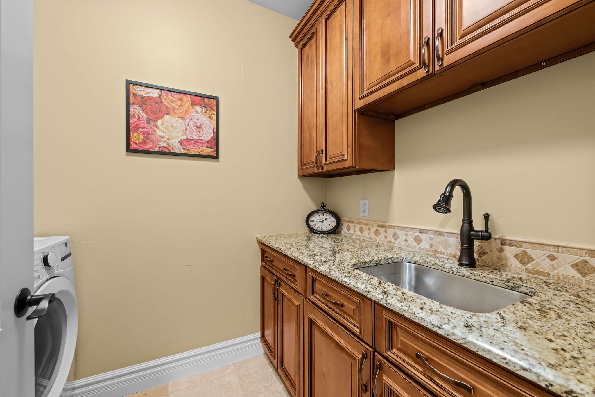 Centrally located upstairs laundry room, cabinetry, utility sink