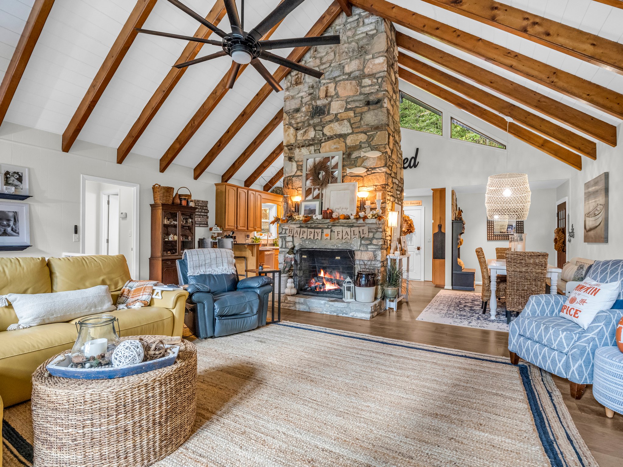 Stunning floor-to-ceiling custom stone fireplace anchors the grand main level living room.