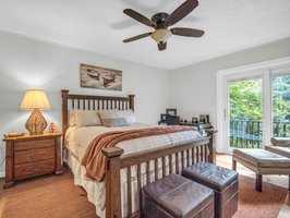 Primary bedroom suite is on the main level overlooking the lake with access onto the wrap-around deck.