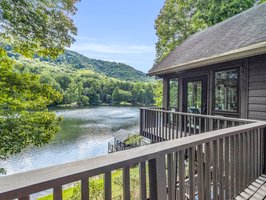 Access the deck from the primary bedroom, overlooking the lake.