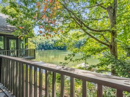 Step onto the back deck overlooking the lake from this guest bedroom.