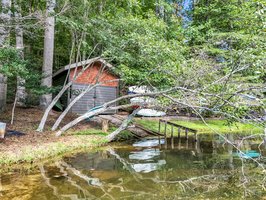 Boathouse with track ramp for easy launch and boat storage offers space for water toys and gear.