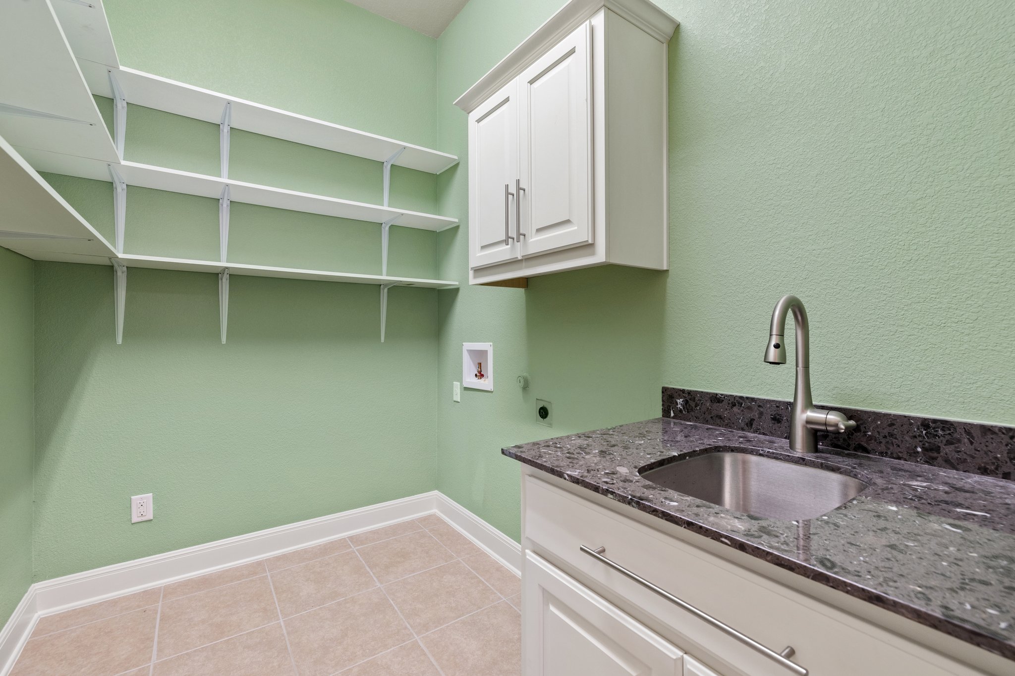 The laundry room has a sink and storage, and is in the hallway near the two bedrooms.