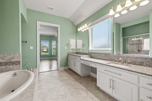 The primary bathroom has two sinks, soaking tub, large walk-in shower and spacious closet.