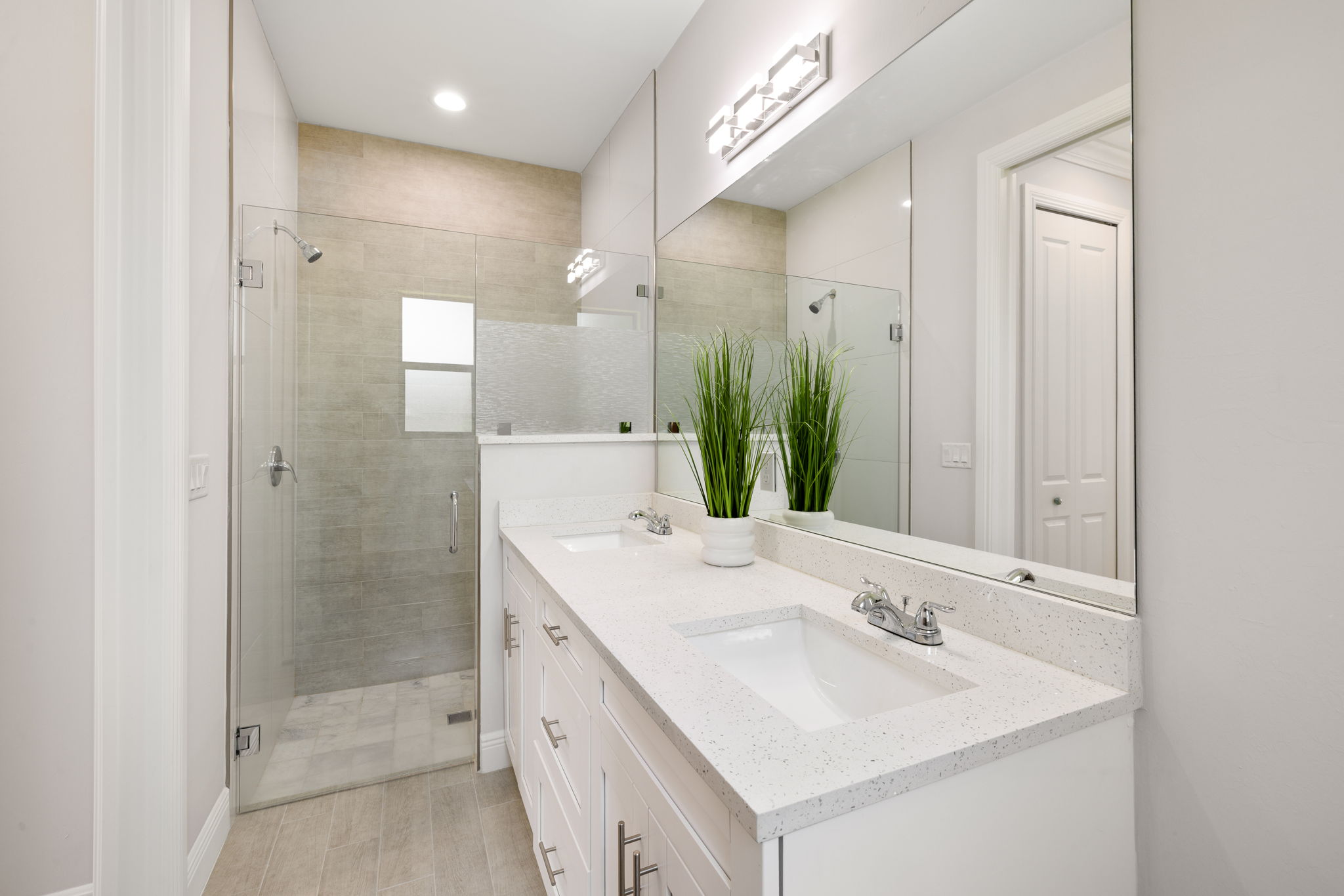 Glass shower door in the master bath with dual sinks.