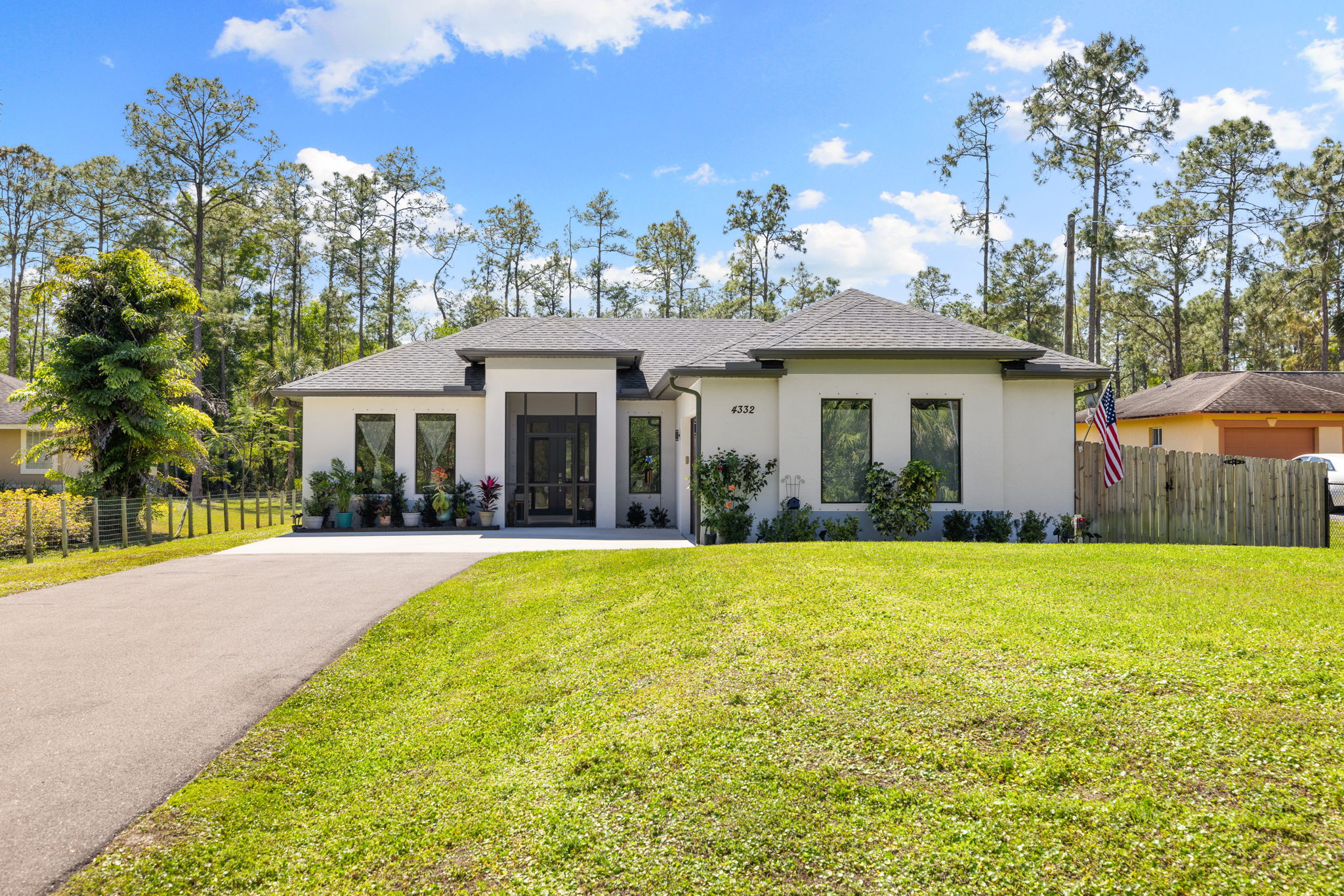 Fully fenced property set amongst a backdrop of trees.