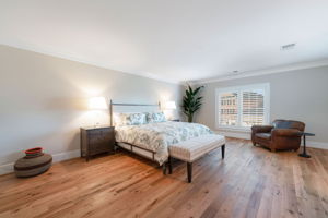 The guest bedroom is large and sleek with new reclaimed hardwood floors.