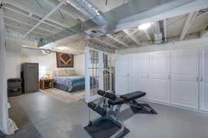 Basement with a guest space. Glass doors and shelving stay.