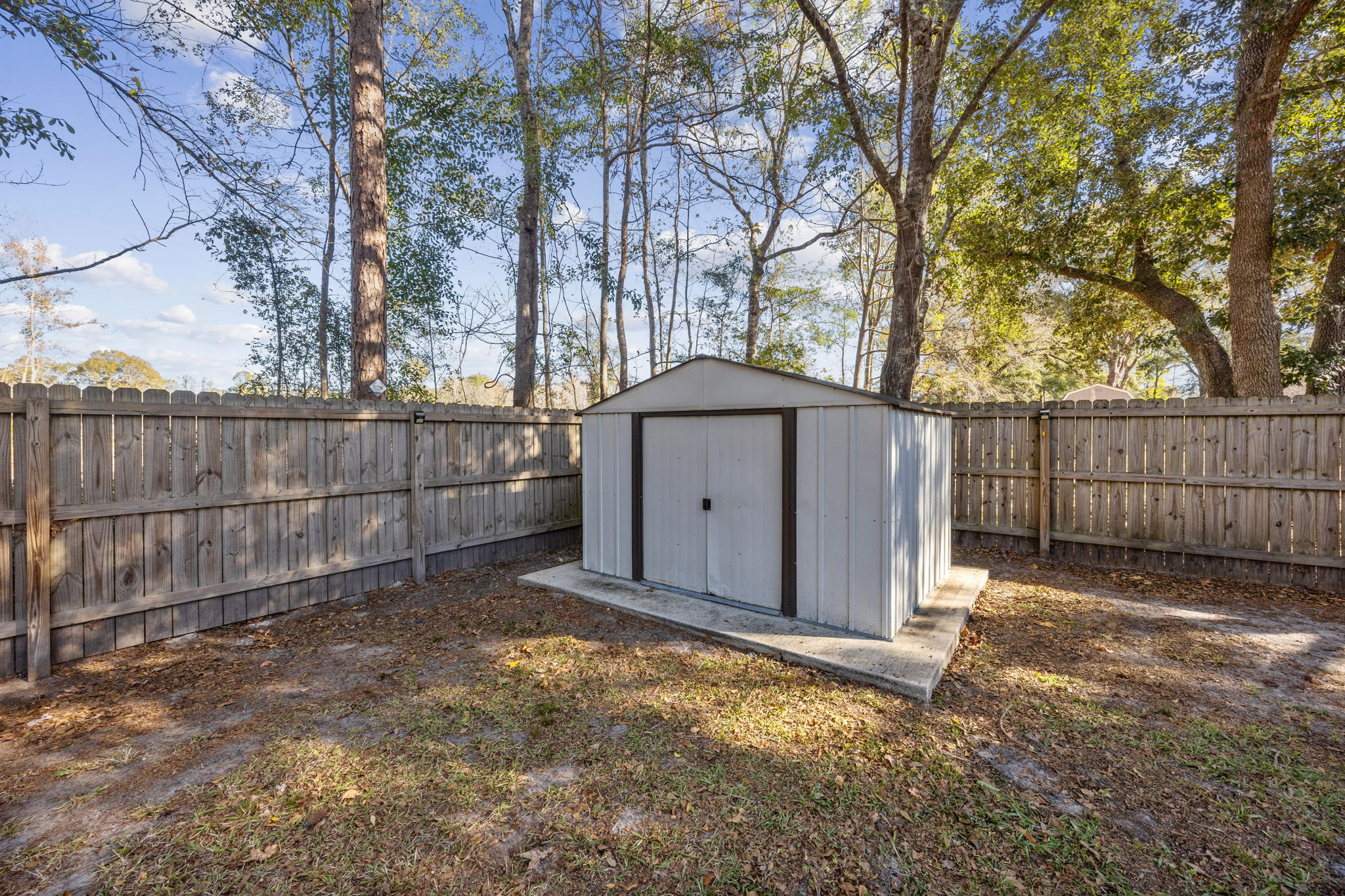 Another Storage Shed with Sliding Doors - notice solar panels on the Fence Posts