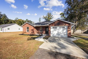 Front of Home with Gutters, Downspouts and Drive-Through Gate on the right