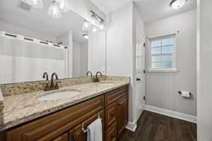 Primary Bathroom with Granite Countertops, New Fixtures, Dual Sinks and Porcelain Tile Floors
