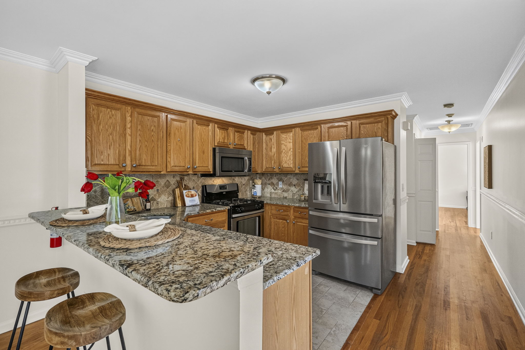 KItchen with ss appliances , including newer fridge, plenty of granite countertops, and spacious breakfast bar.