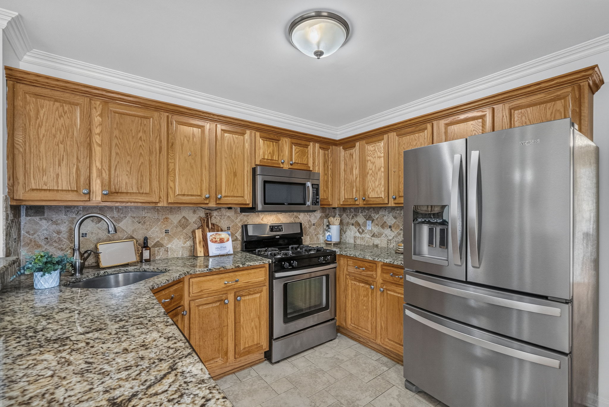 KItchen with ss appliances , including newer fridge, plenty of granite countertops, and spacious breakfast bar.