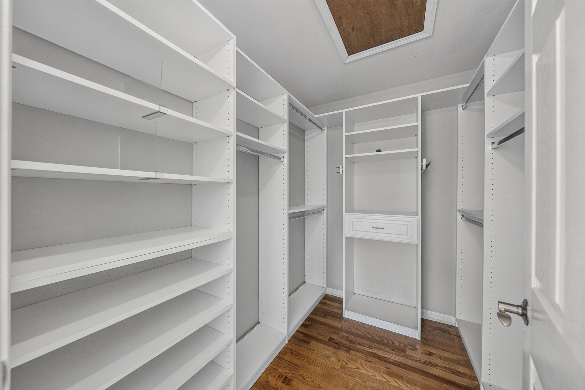 Primary Bedroom with walk in closet with built ins, valet, drawers-including a velvet two tier jewelery drawer, private bathroom with shower and attic access from WIC.
