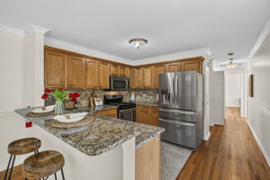 KItchen with ss appliances , including newer fridge, plenty of granite countertops, and spacious breakfast bar.