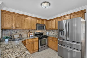 KItchen with ss appliances , including newer fridge, plenty of granite countertops, and spacious breakfast bar.