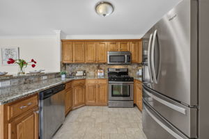 KItchen with ss appliances , including newer fridge, plenty of granite countertops, and spacious breakfast bar.