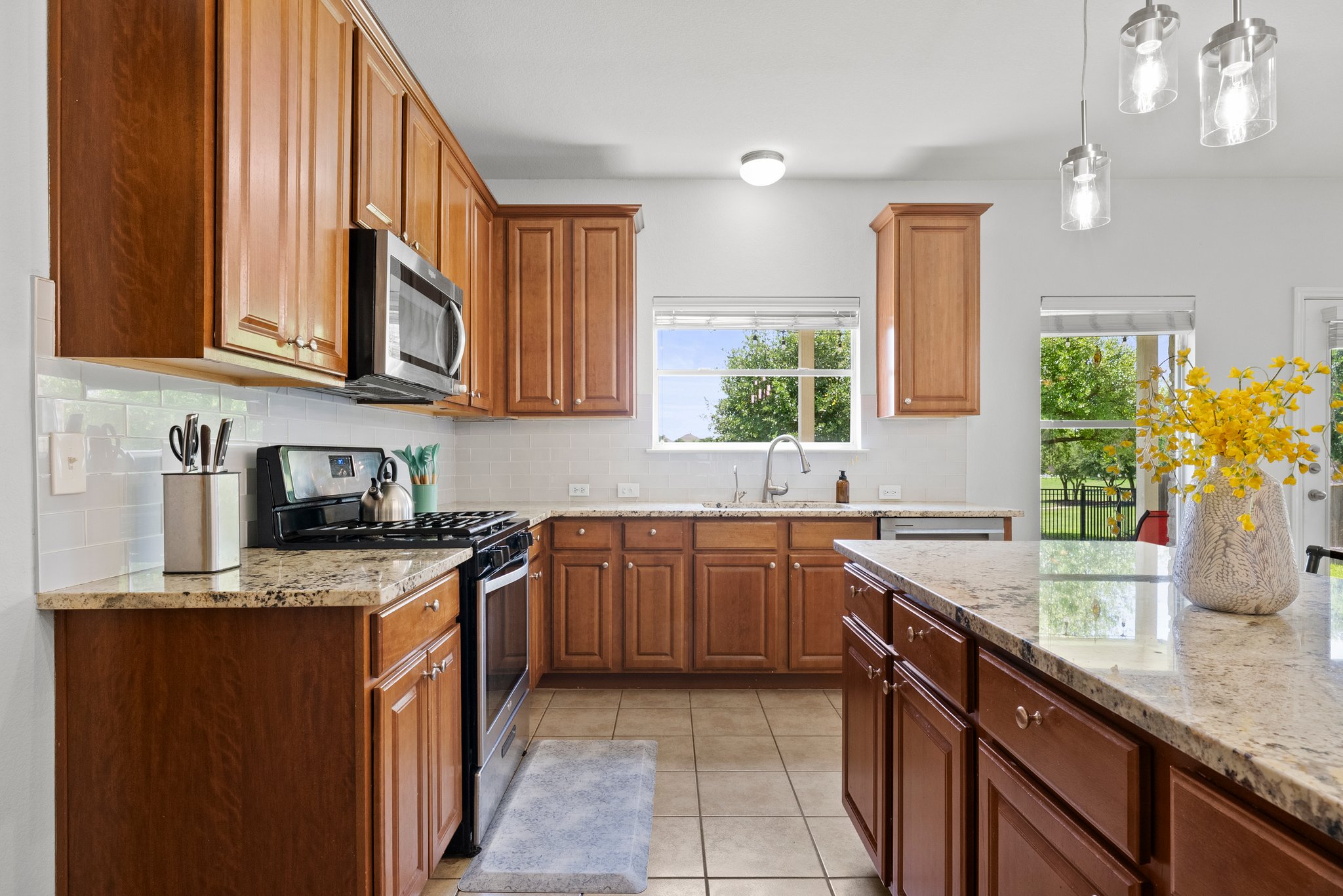 The kitchen window looks into the lush back yard and a community pond.