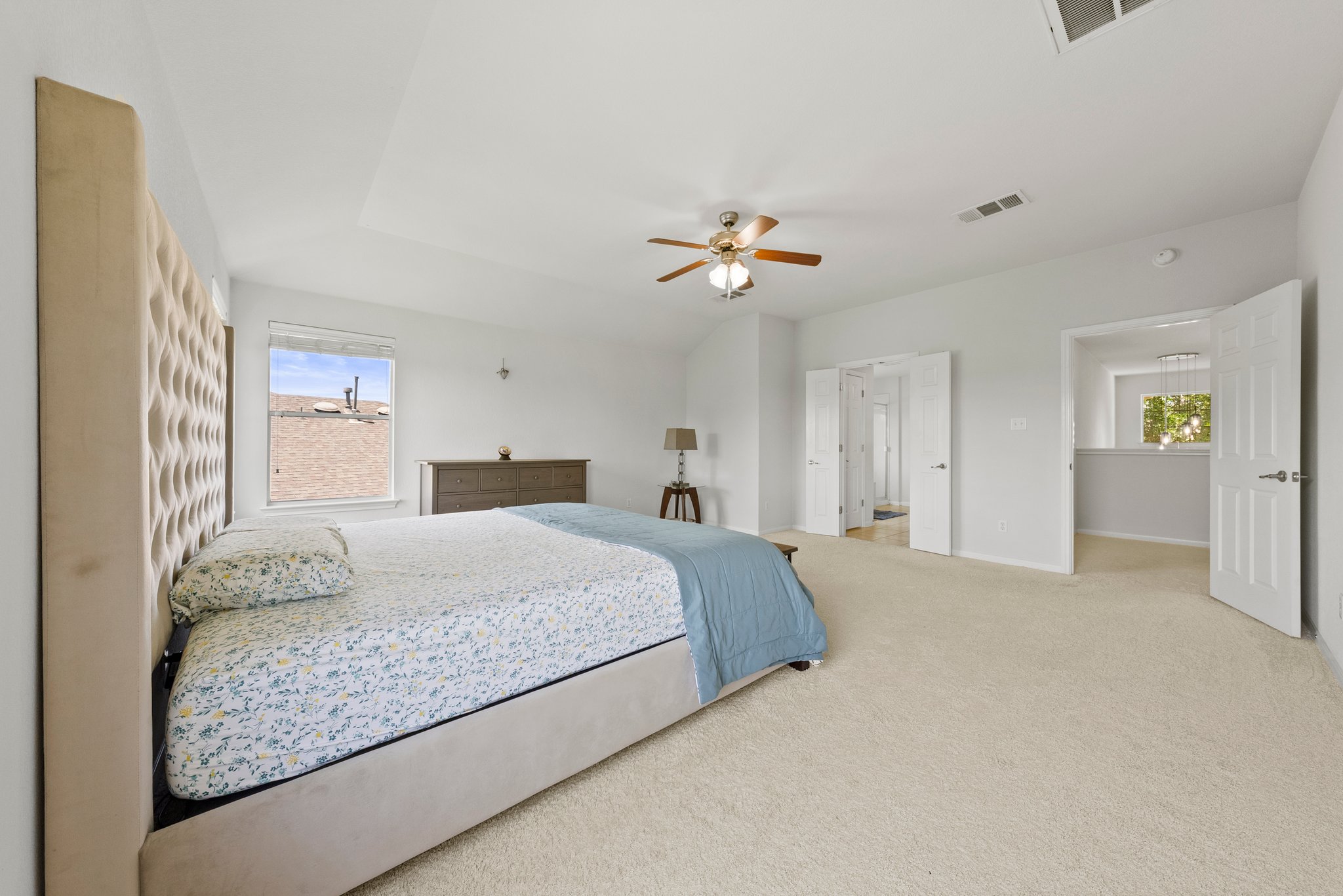 Large, upstairs primary bedroom with windows looking out into a community pond.