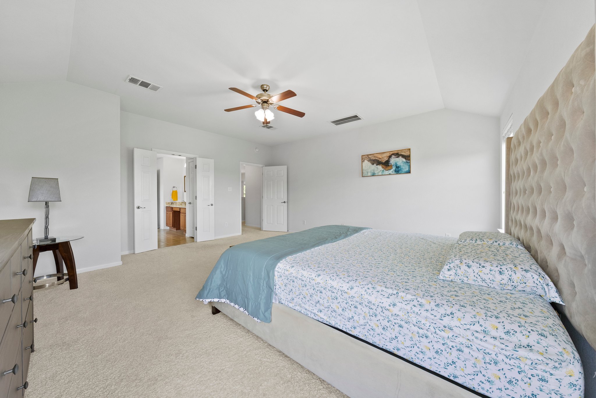 Large, upstairs primary bedroom with windows looking out into a community pond.