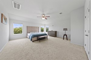 Large, upstairs primary bedroom with windows looking out into a community pond.