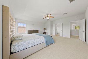 Large, upstairs primary bedroom with windows looking out into a community pond.
