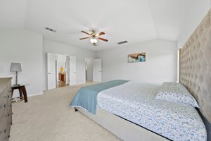 Large, upstairs primary bedroom with windows looking out into a community pond.