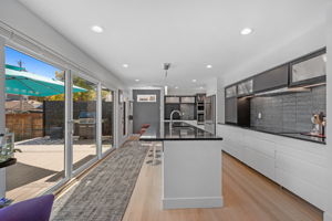 Quad sliders in the kitchen bring in natural light and create seamless indoor/outdoor living