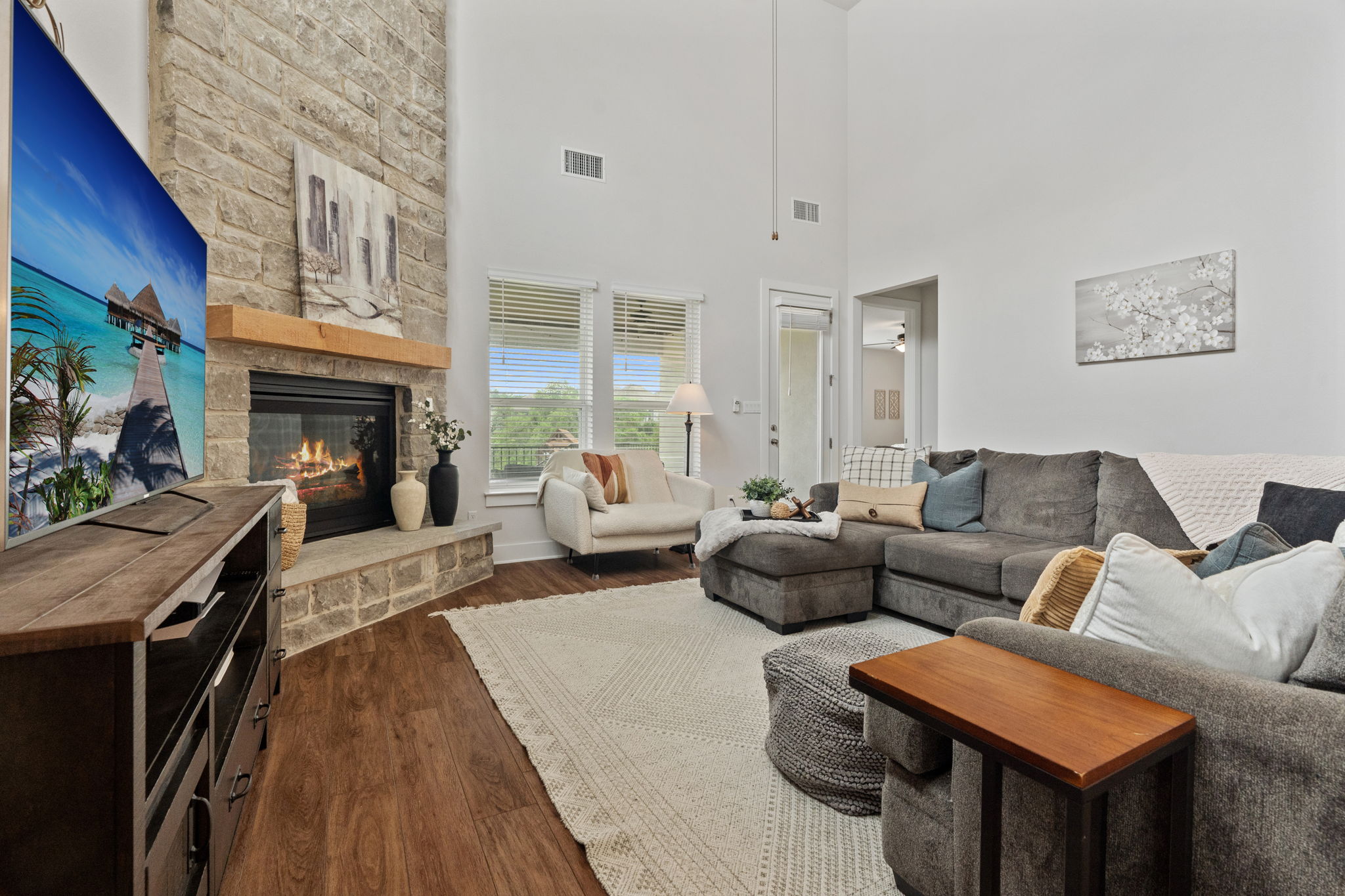 The family room features vaulted ceiling and a floor-to-ceiling stone fireplace.