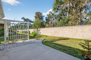 Rear Patio with Yard, Wall, and Woods