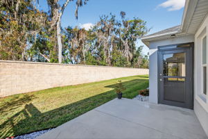 Rear Patio with Yard, Wall, and Woods