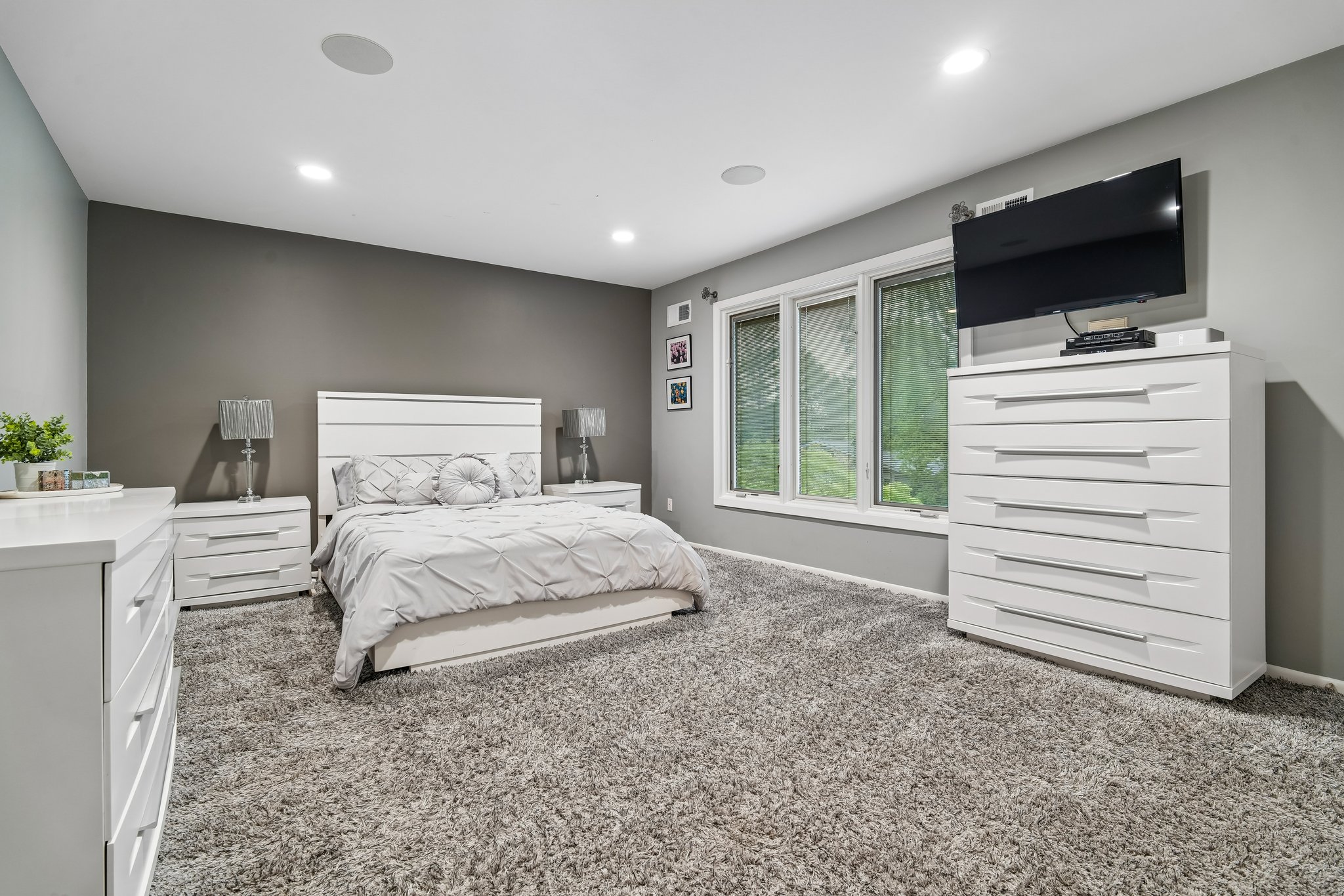 Continuity of design shines in the second of three second floor bedrooms, featuring walls of windows. These spacious rooms offer exceptional storage with expansive double-door closets ensuring every family member enjoys the same level of comfort.