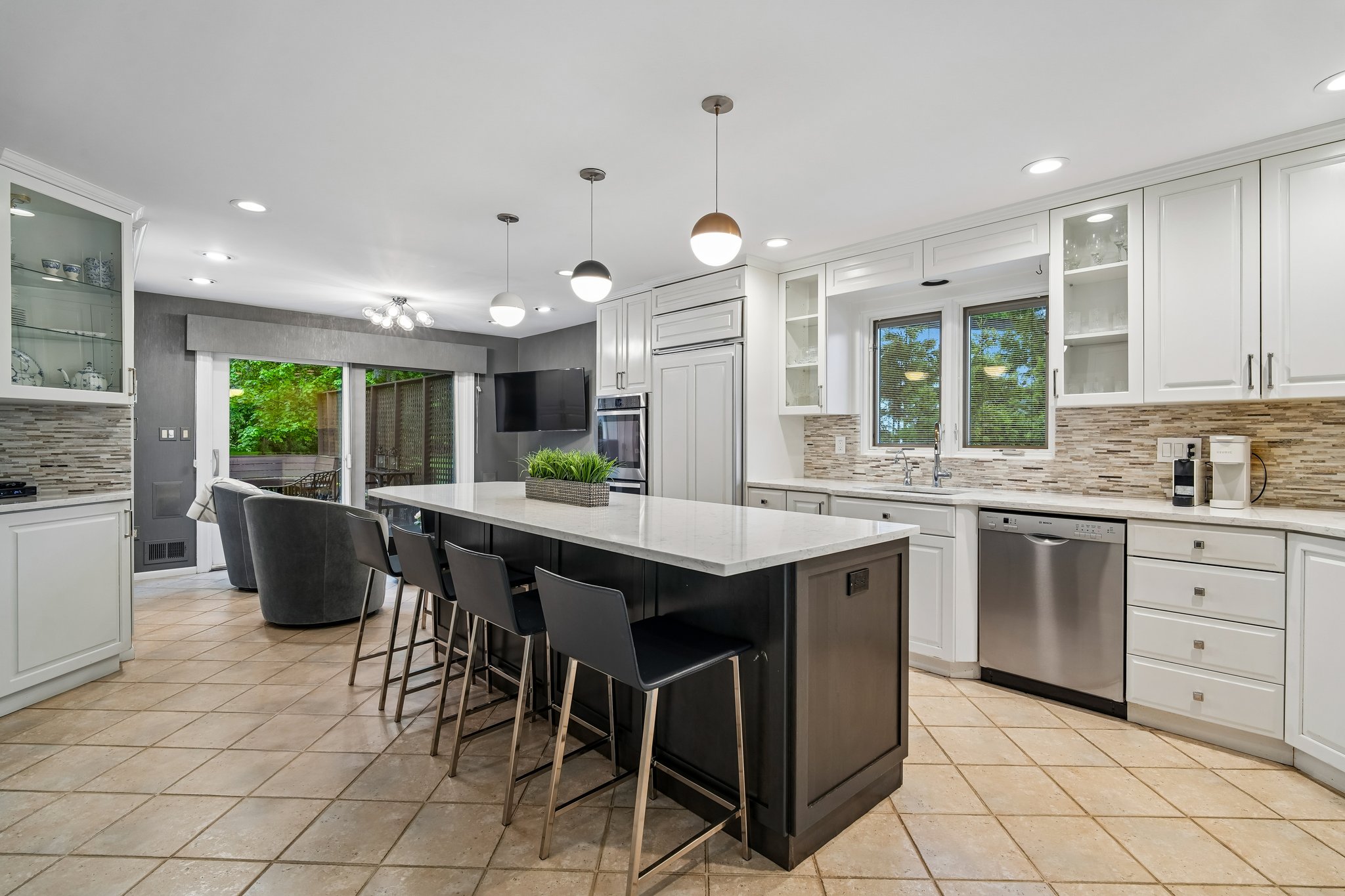 Another view of the kitchen with windows above the sink and a sliding glass door that lets in plenty of sunshine.