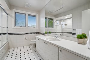First of two second floor hall baths feature a classic and cohesive design, highlighted by a decorative tile border that perfectly compliments the matching tile flooring for a polished seamless look.