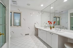 Second of two second floor oversized hall baths is designed for effortless mornings, featuring dual-sinks, custom cabinetry and dedicated make-up vanity. Wrapped in walls of mirrors that enhance the room's light and scale, this space is completed by a classic tub-over shower for ultimate versatility.