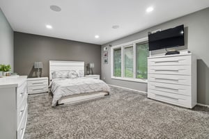 Continuity of design shines in the second of three second floor bedrooms, featuring walls of windows. These spacious rooms offer exceptional storage with expansive double-door closets ensuring every family member enjoys the same level of comfort.